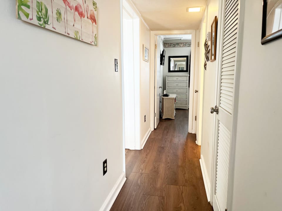 Hallway from master to second bedroom. Hall bath on right, living room to left. 