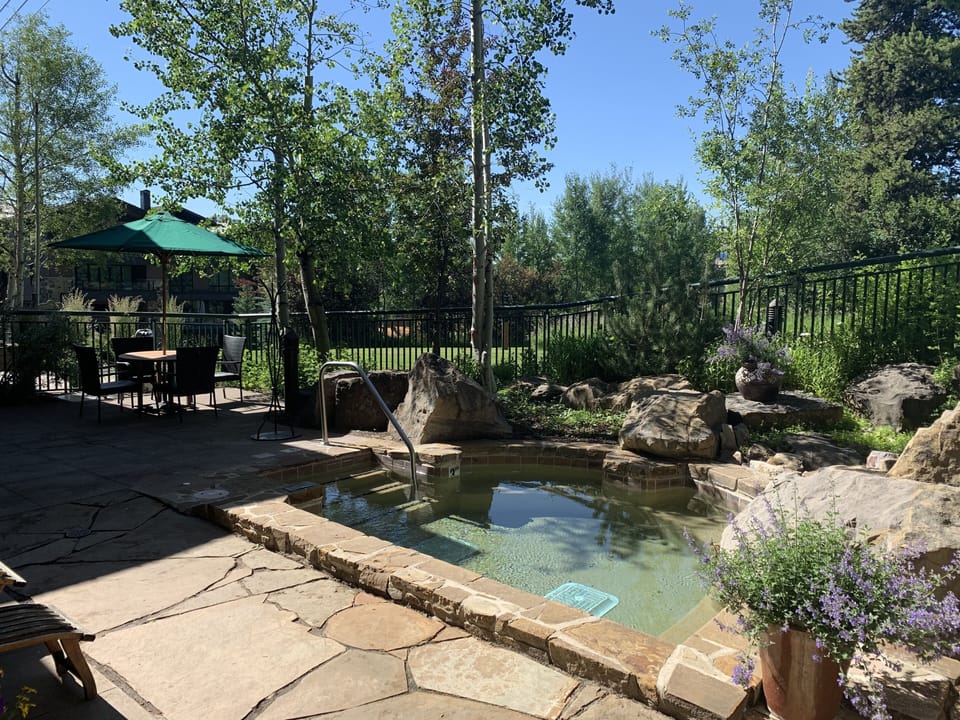 4 Hot tubs among the rocks and evergreens in the Summer.