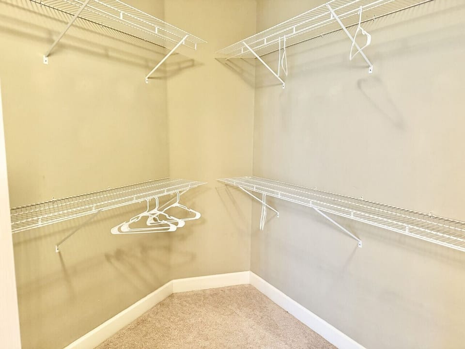 Large walk-in closet with lots of storage space for clothes and luggage.