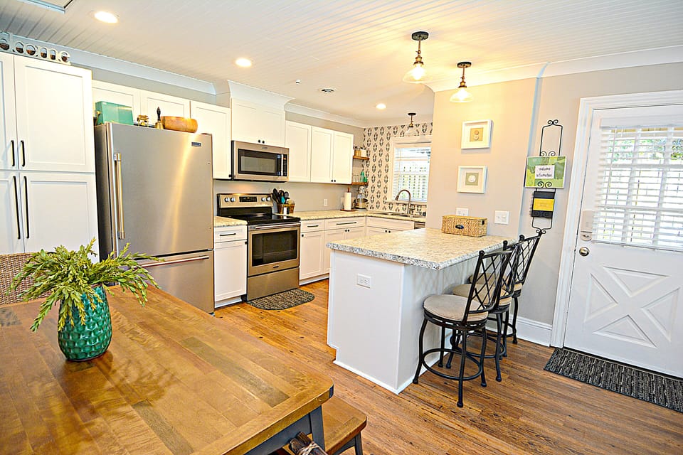 Dinning table, counter seating and kitchen.