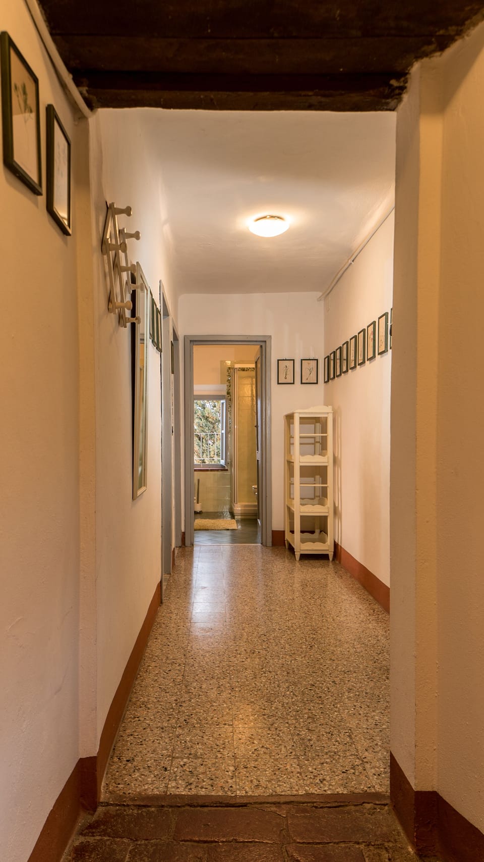 The corridor leading to the bedrooms and to the green bathroom at the end of it.