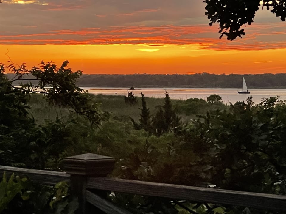 Sunset view of the bay with sailboat from upper deck