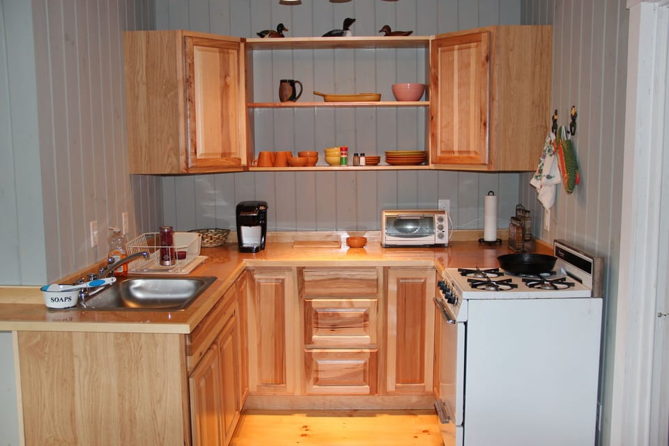 Small, compact quaint kitchen with original restored gas stove.