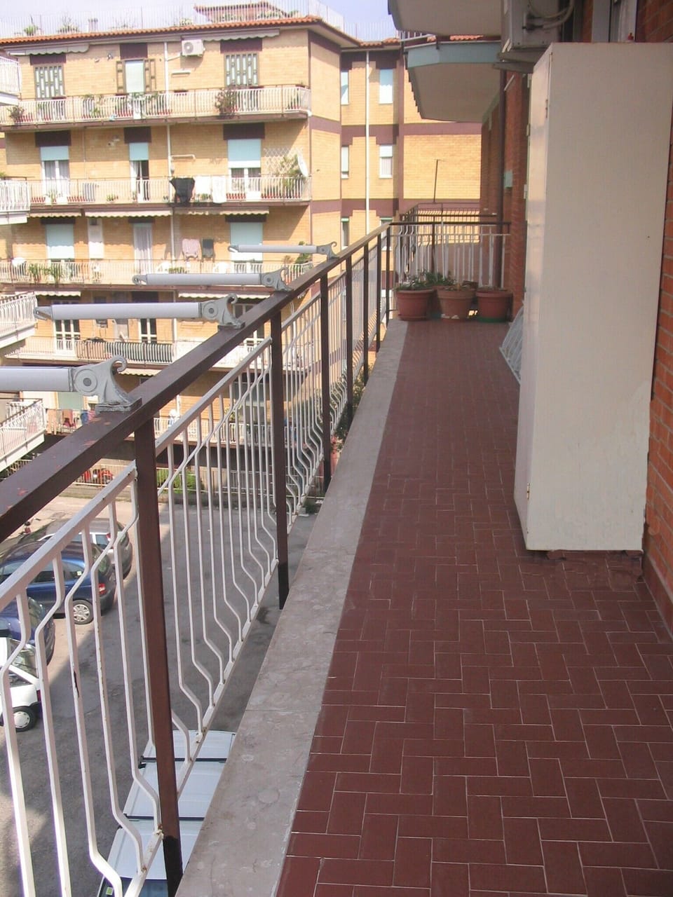 Large balcony with space for table and chairs and view of parking area below