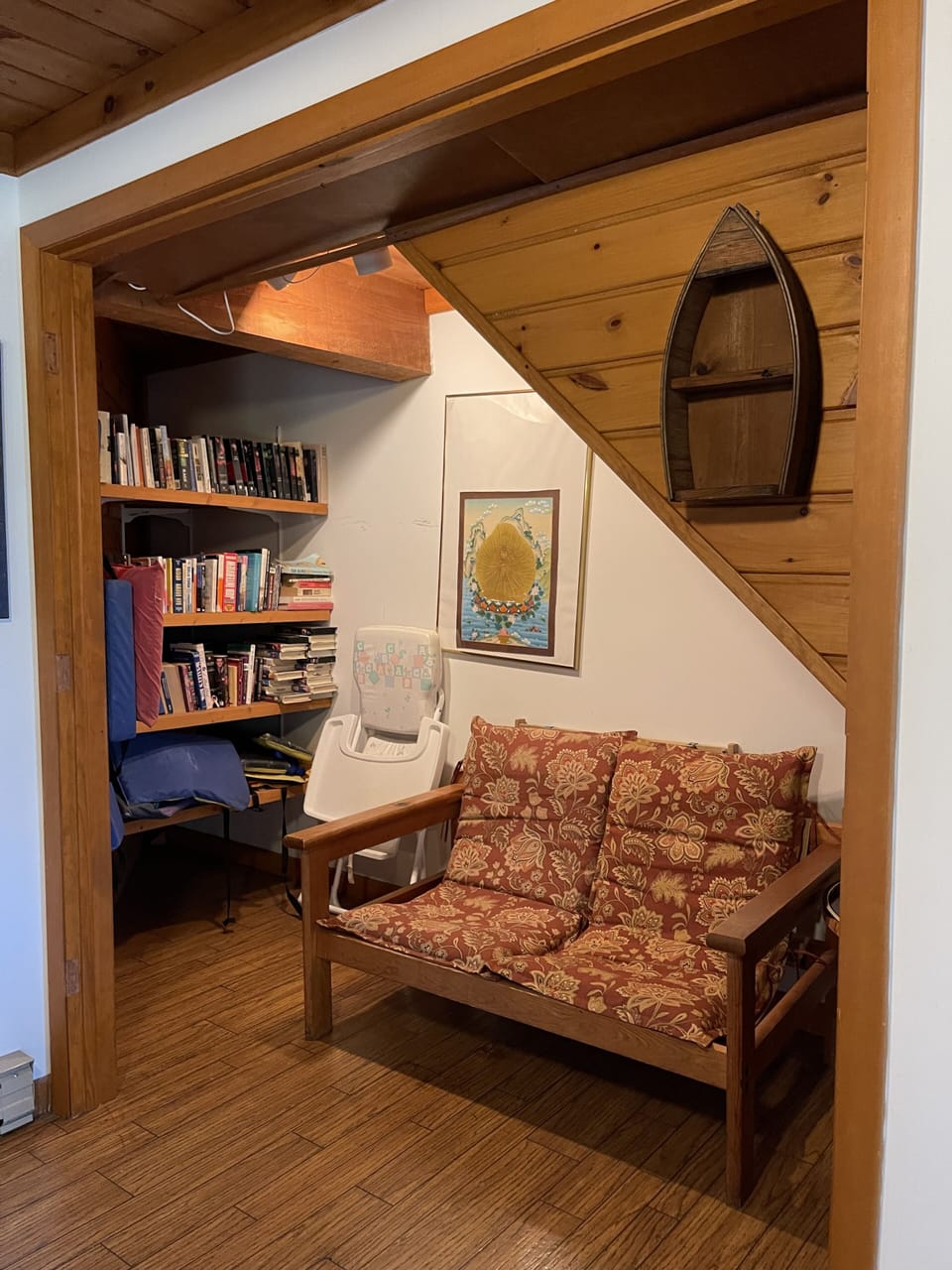Storage area under the stairs with books, life preservers, and games.