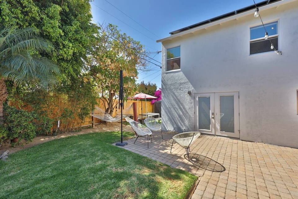 Step into a serene outdoor space thoughtfully designed for relaxation and productivity. Nestled in the vibrant South Park neighborhood, this backyard retreat features a cozy hammock for unwinding under the dappled shade of lush trees. The picnic tabl