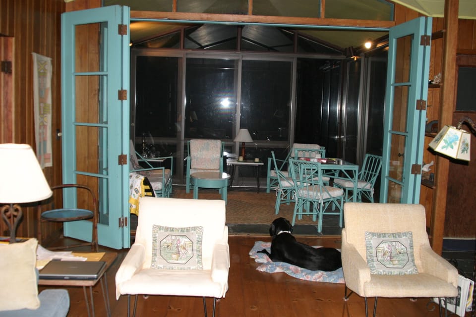 From living room looking back to a glassed in back porch overlooking woods