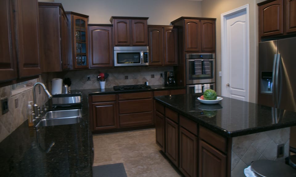 kitchen w/ granite counter tops, stainless steel appliances and walkin pantry