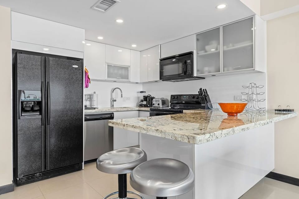 Picture yourself preparing your favorite meals in this fully equipped kitchen with granite counters, modern appliances, and an inviting breakfast bar—perfect for quick bites or evening cocktails.