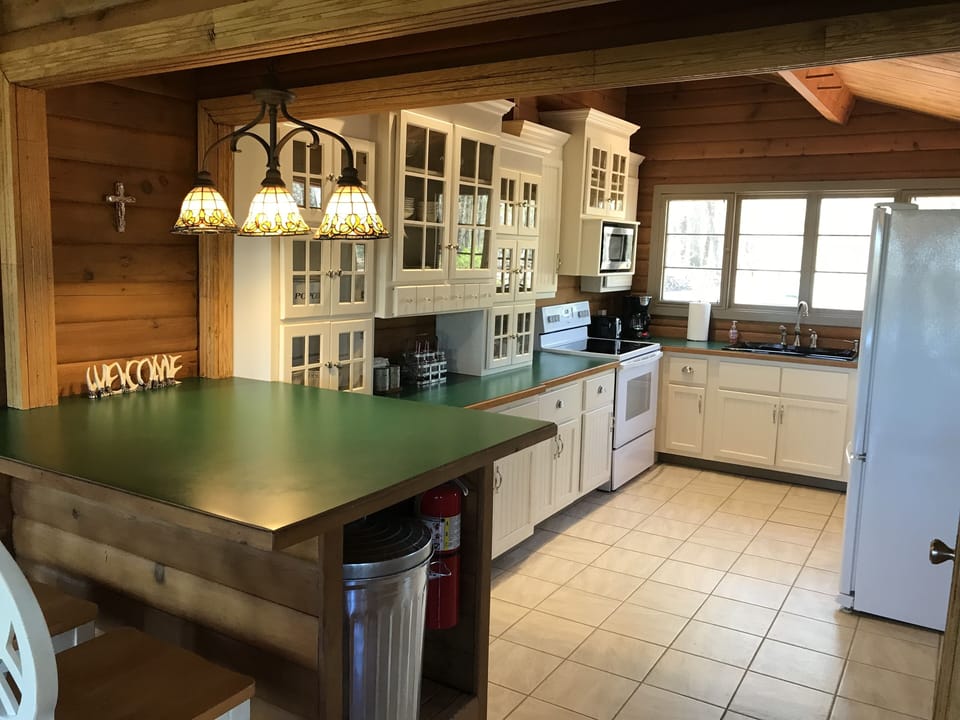 The kitchen is stocked with dishes, pots, pans...