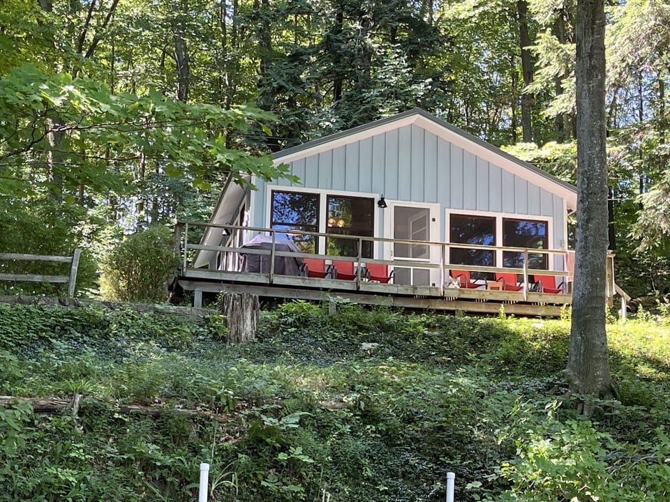 Blue Cottage with deck overlooking lawn and beach