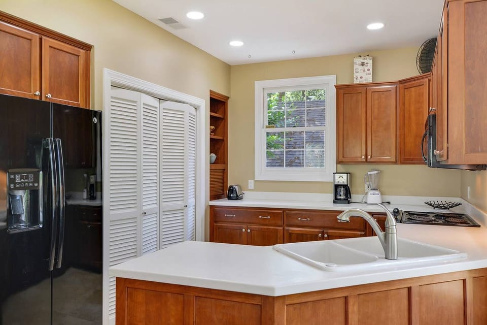 Fully stocked Kitchen with easy view of Family Room TV and view of Lagoon.
