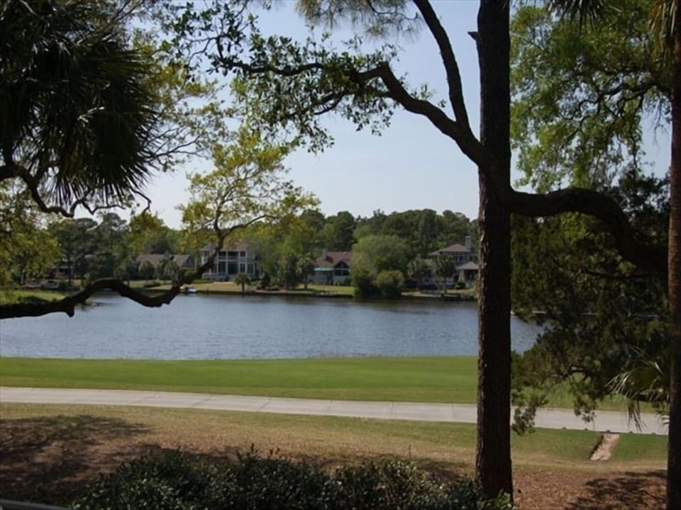 view of golf course and water from living room and deck