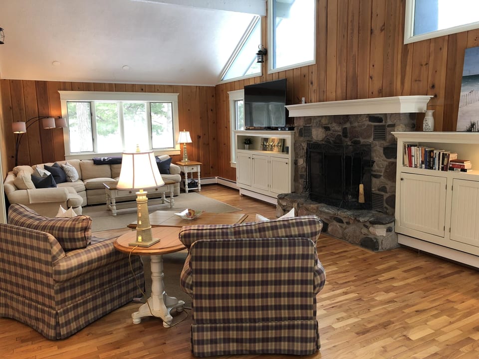 Vaulted ceiling great room w/wood burning stone fireplace and 65" TV