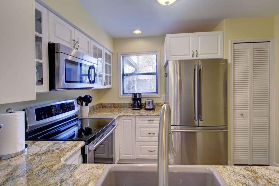 Kitchen With Stainless Appliances - Granite counters, white cabinetry, and stainless appliances support simple meals during the stay.