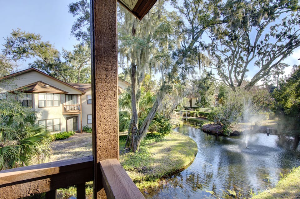 Screened Porch With Lagoon View - The screened porch overlooks the Harbour Oaks lagoon, trees, and community grounds.