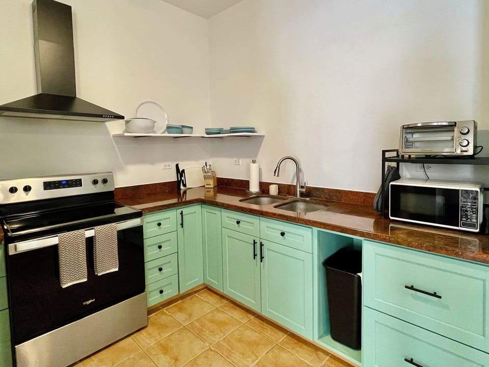 Kitchen with coffee machine, microwave, blender & toaster oven. 