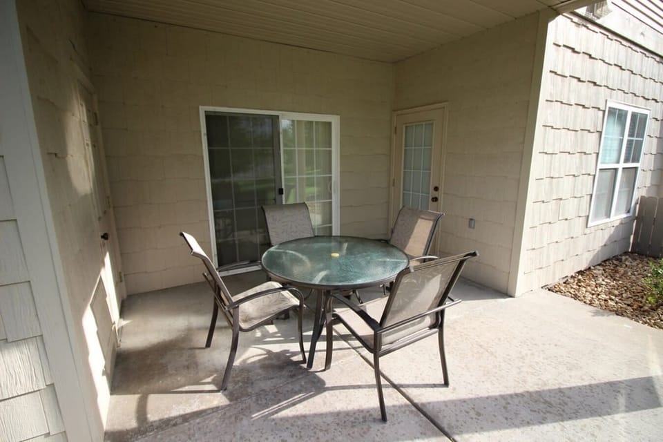 Patio equipped with table and four chairs.