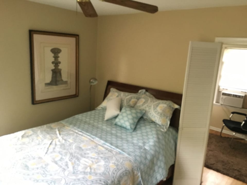 Queen size bed with premium linens and four pillows.