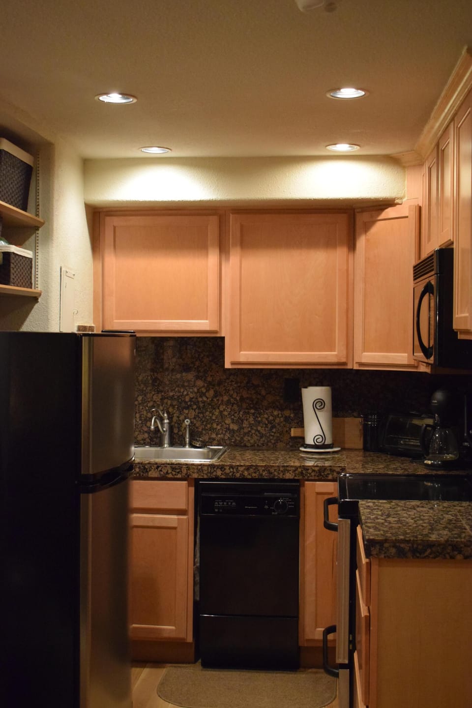 Kitchen with full size refrigerator, microwave, glass top range, and dishwasher.