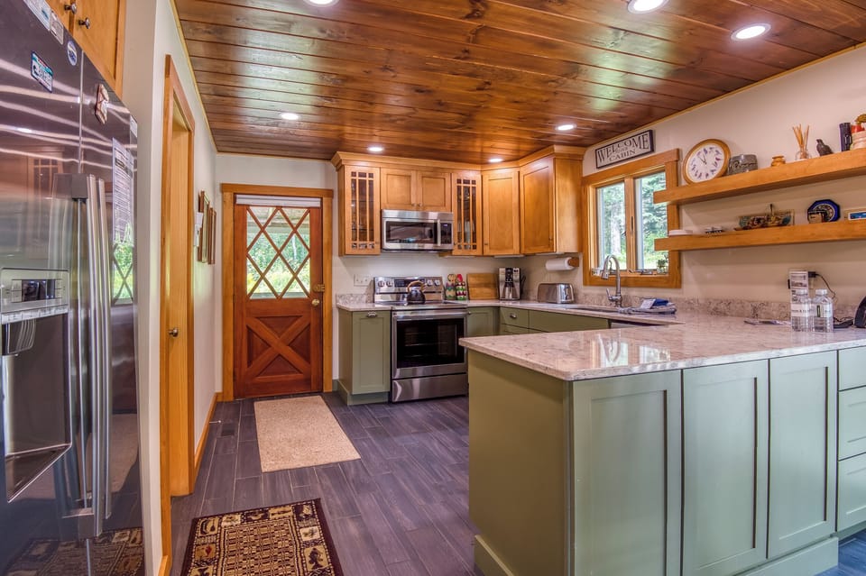 Fully applianced kitchen with view of entryway