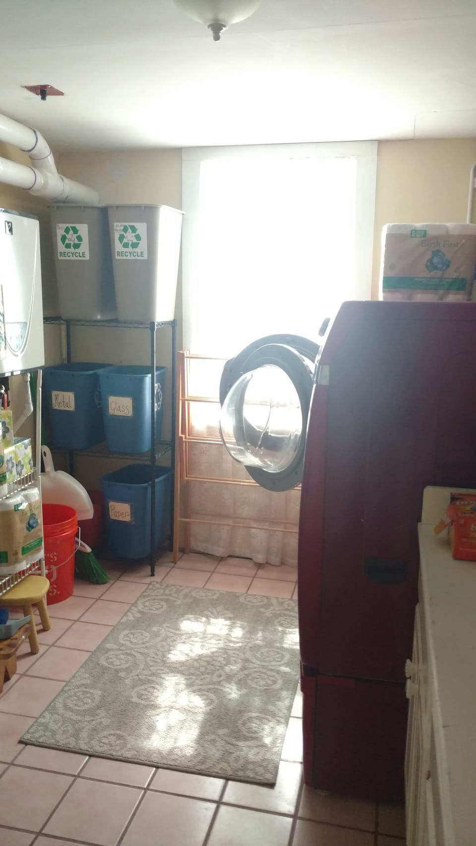 Recycling and on demand water heater located in laundry room next to kitchen.