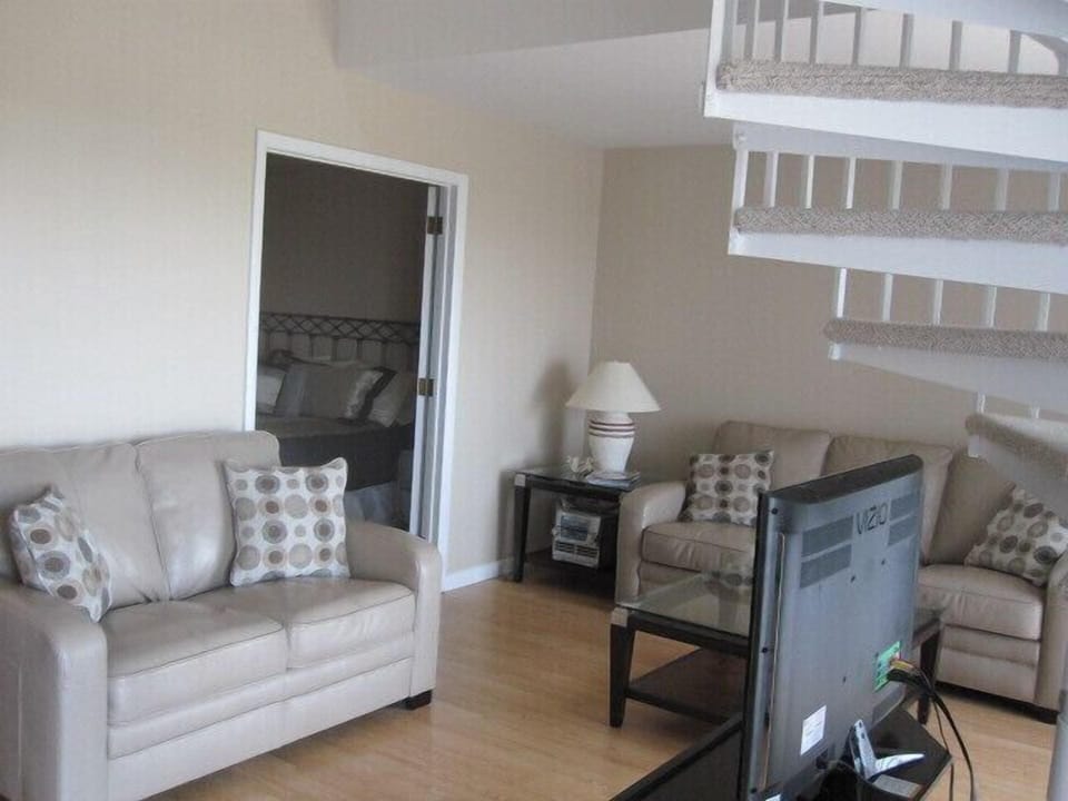 Living Room with Leather Sofas and Spiral Staircase leading to Loft