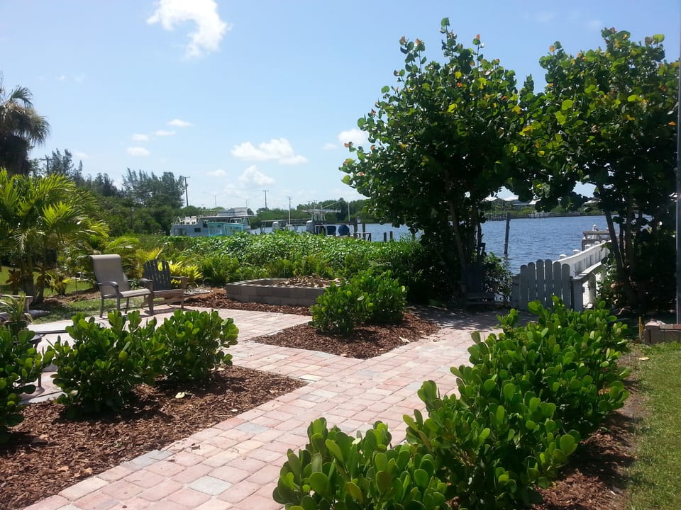 Bayfront sitting area with firepit, walkway to boat dock.