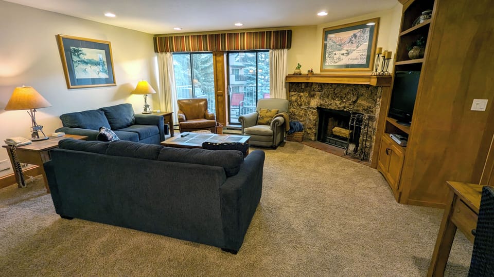 Condo A-3 living room with wood fireplace and balcony w/ propane BBQ grill