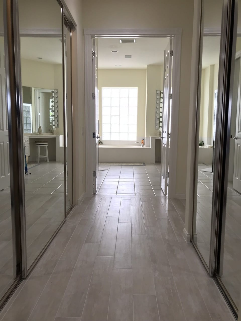 Looking into Master bath with mirrored closets on both sides