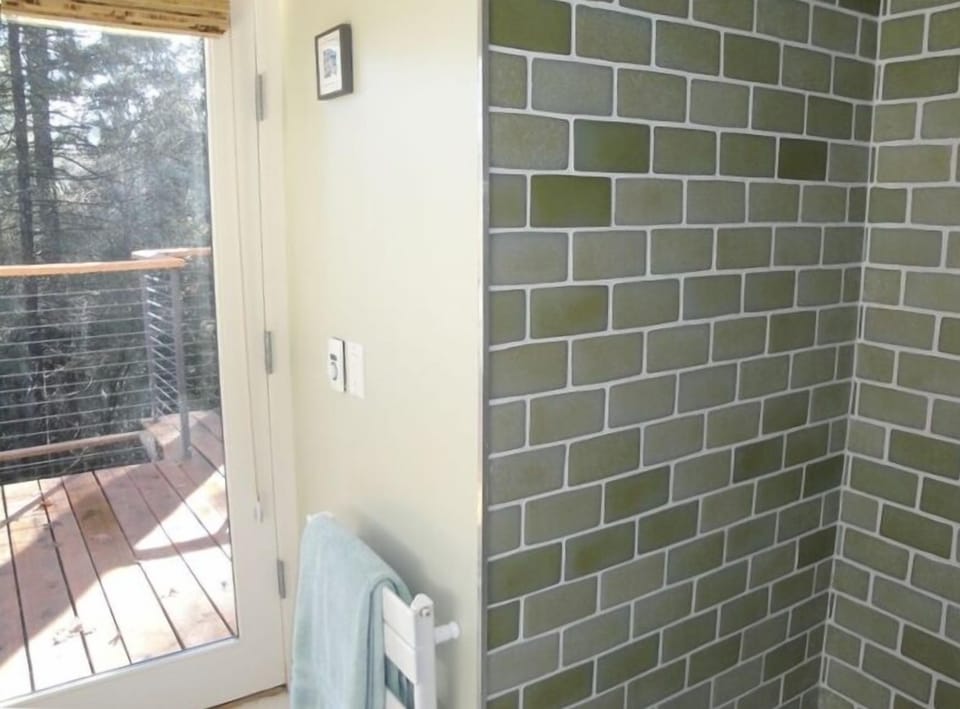 recycled wine bottle shower, towel heater and door to deck