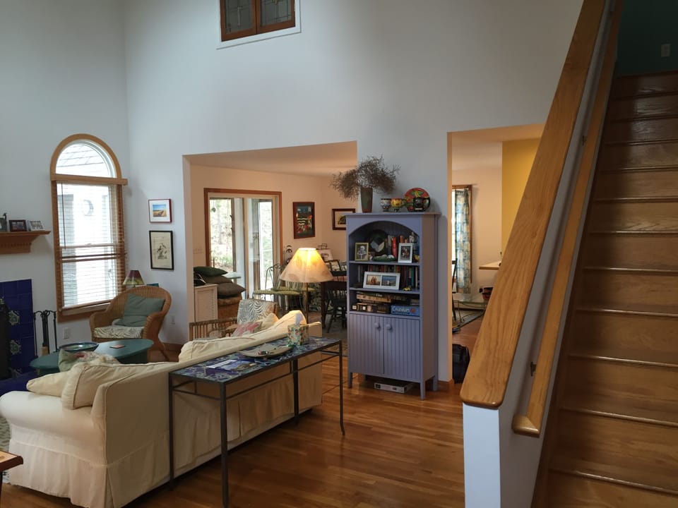 View of living room and stairs. Dining area and door to sun porch in background