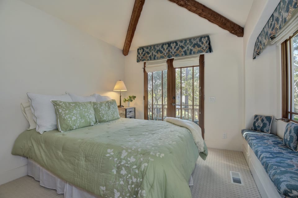 Third bedroom, with queen size bed. French doors that open to wooden deck.