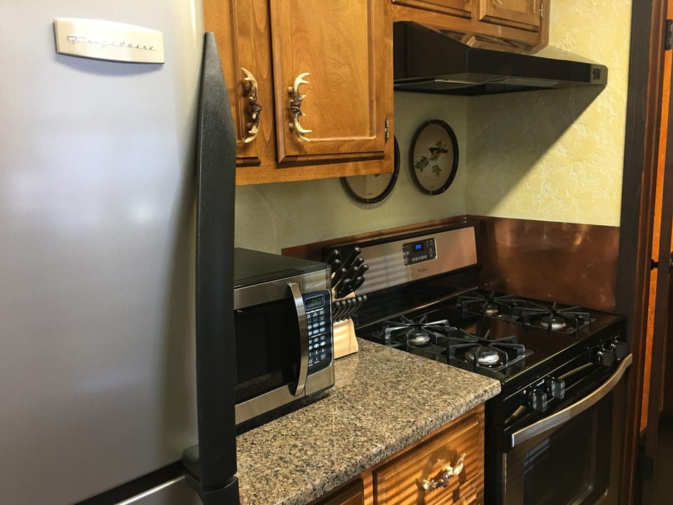 Gas Range In the fully-equipped kitchen. New dinnerware and small appliances.