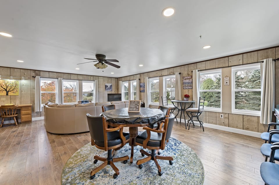 Game room w/ multiple game table, sectional sofa with 2 recliners and smart TV.