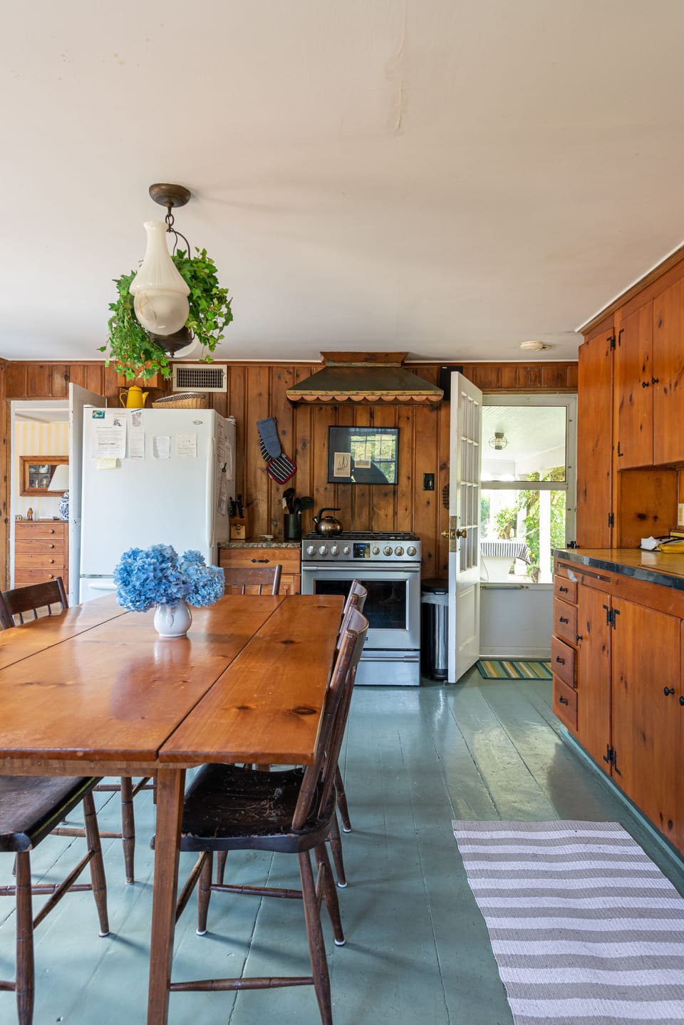 Kitchen with large gas stove & door to porch