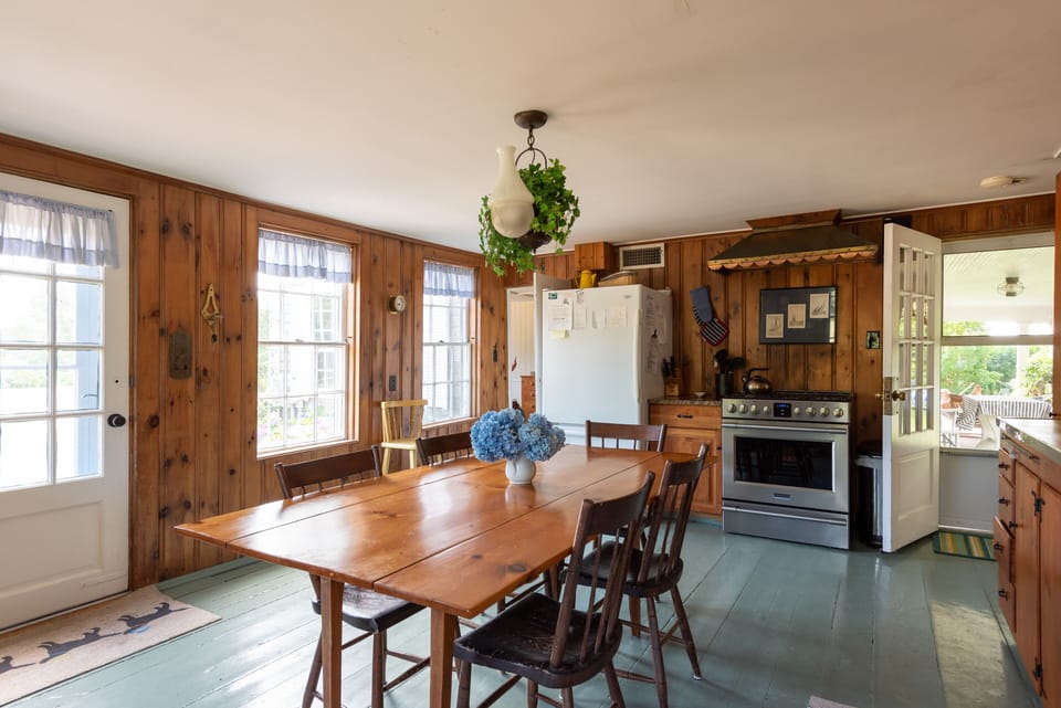 Kitchen with large gas stove & door to porch