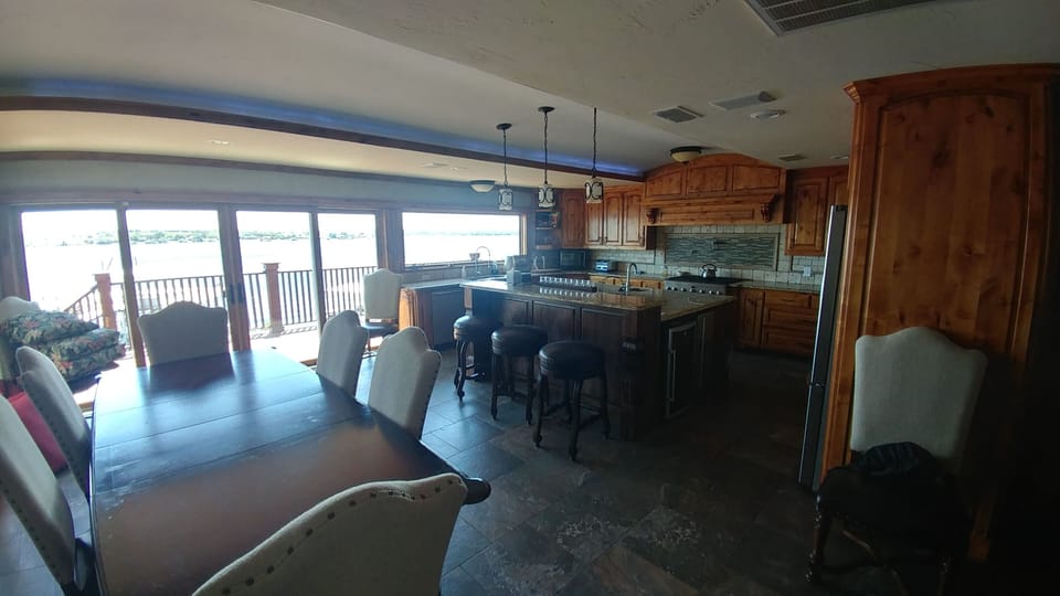 View of open kitchen and dining area looking out to lake. 
