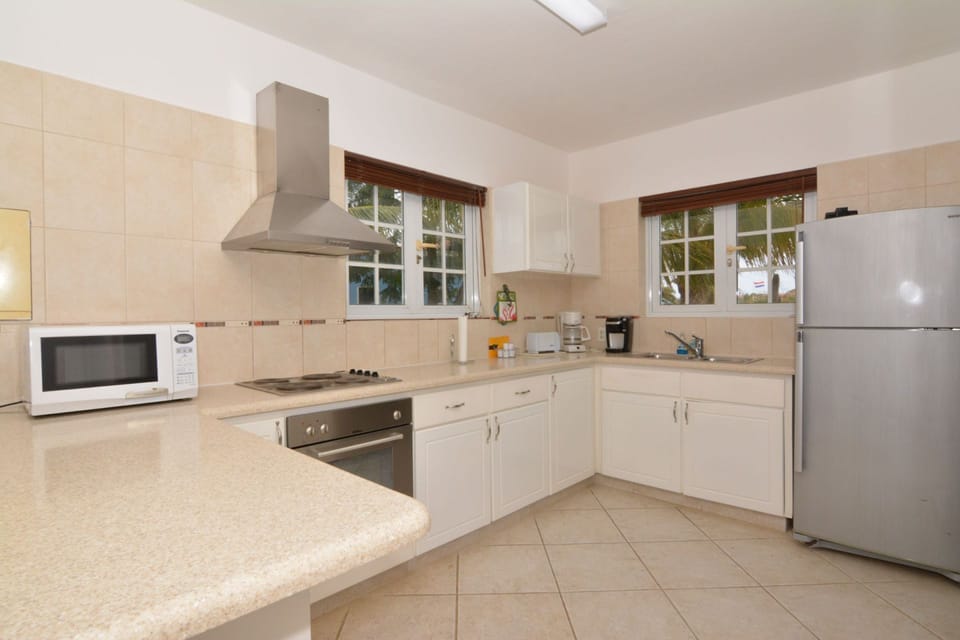 View of fully equipped kitchen showing microwave, stove and refrigerator