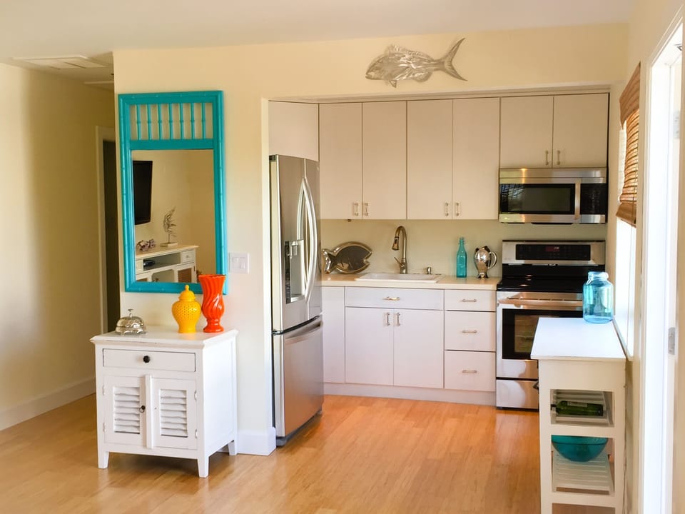 Bright, fully equipped kitchen white cabinetry, & stainless-steel LG appliances.