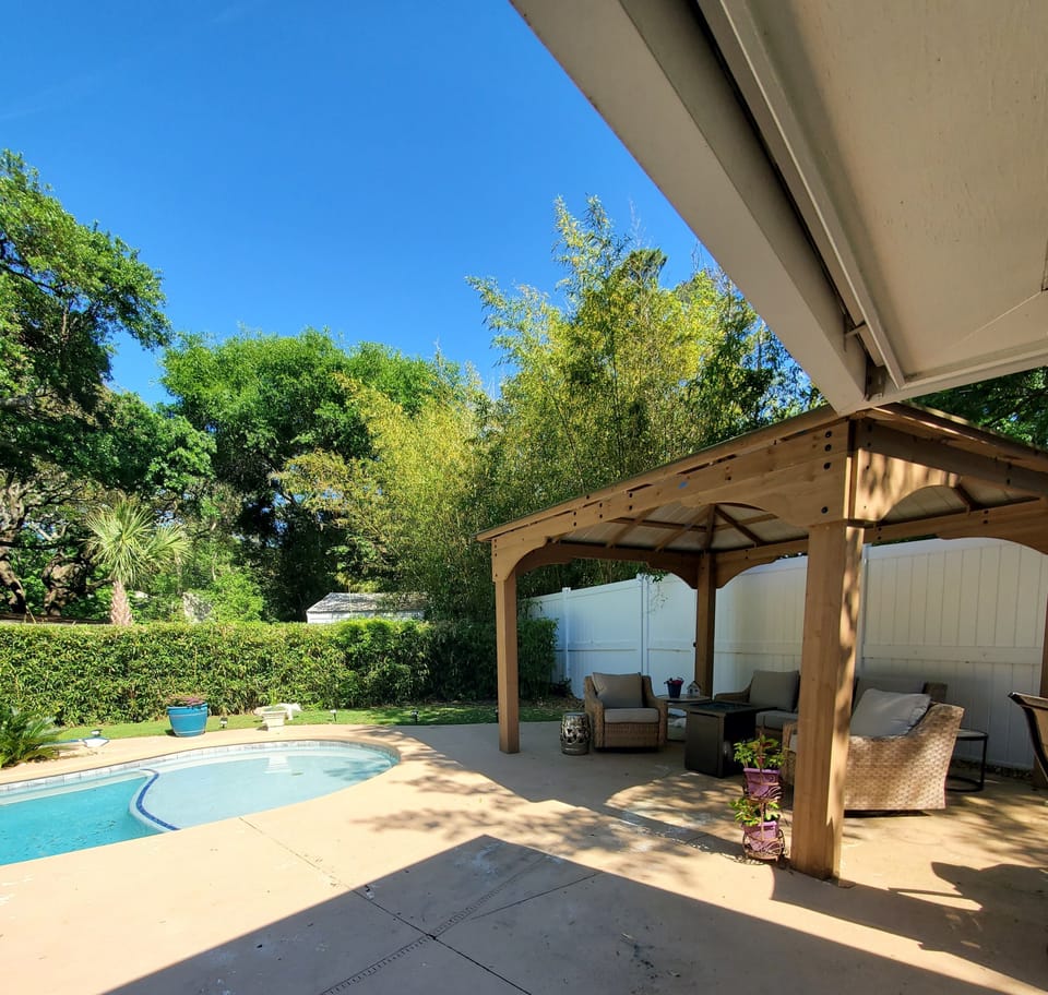 Covered Pergola with outdoor seating, fan, and propane fire-pit.