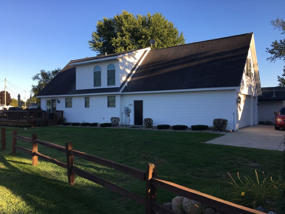 Large side yard and paved parking area outside the attached two-car garage 