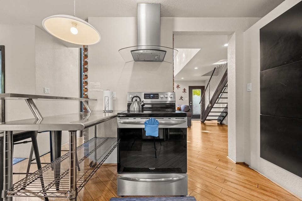 Fully stocked kitchen with stainless countertops, appliances, spices, dishware