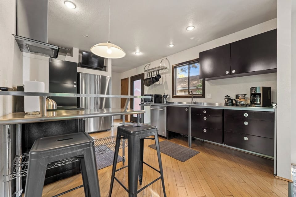 Fully stocked kitchen with stainless countertops, appliances, spices, dishware