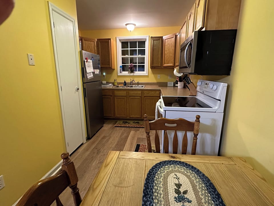 Table for four sits between the  kitchen and living area.