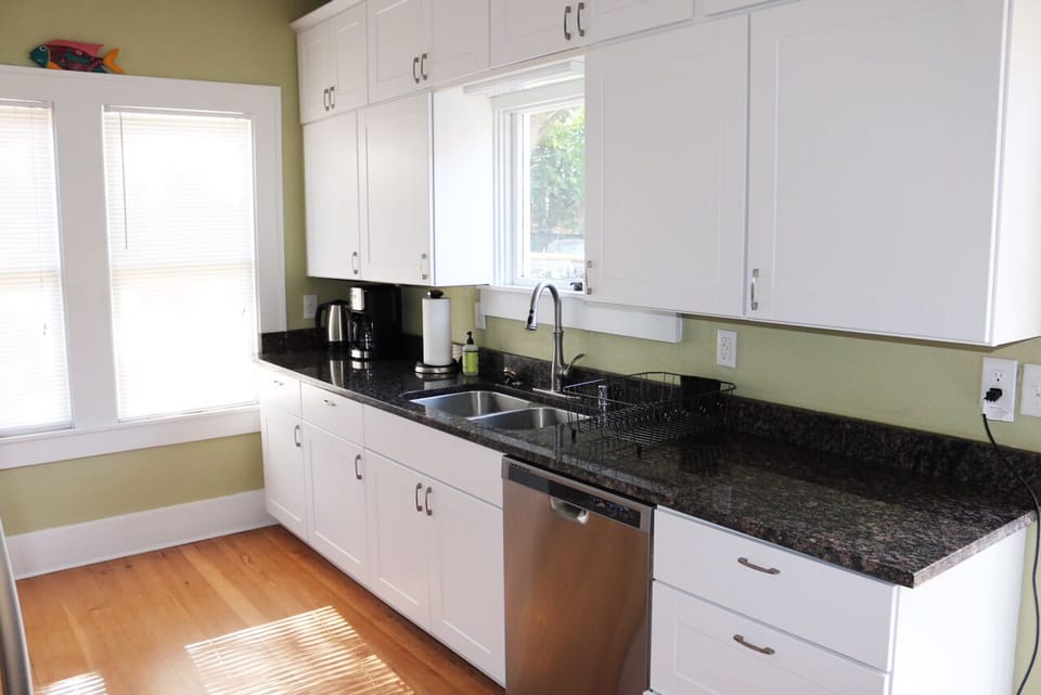 Kitchen with dishwasher, coffee maker, electric tea kettle.