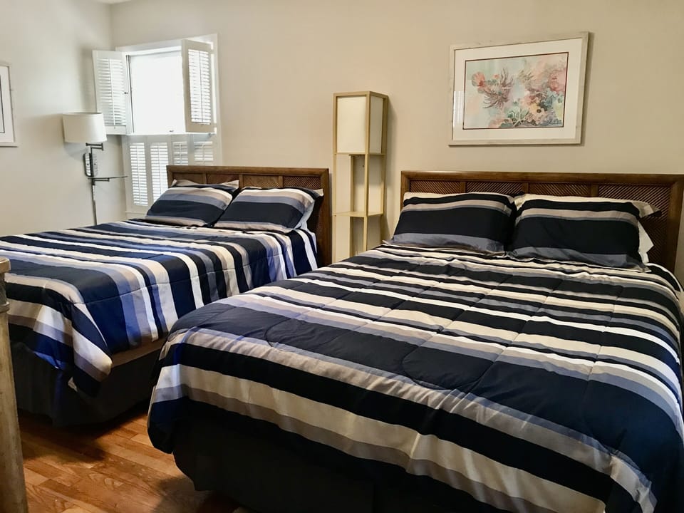 Upper level rear bedroom with two queen beds.
