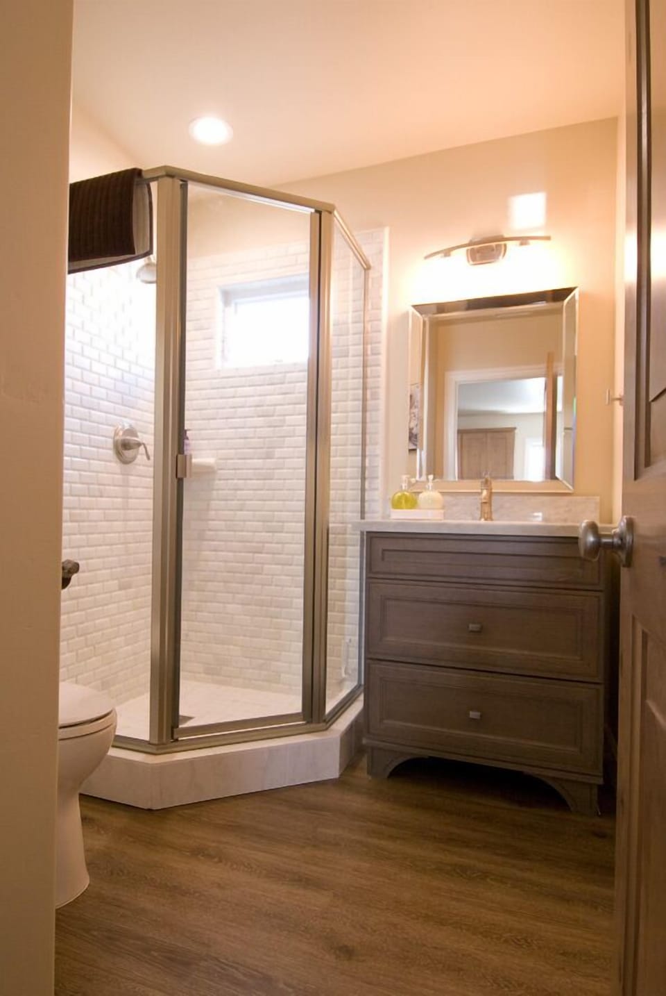 Upstairs bathroom with cool corner shower marble stone finish.  