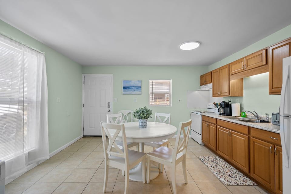 Your bright kitchen offers everything needed for home-cooked meals, with warm wood cabinets and a cozy dining table perfect for morning coffee.