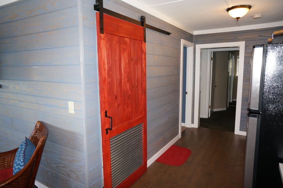Sliding barn door covering stacked washer/dryer.  Hallway to bedrooms 1&2, Bath.